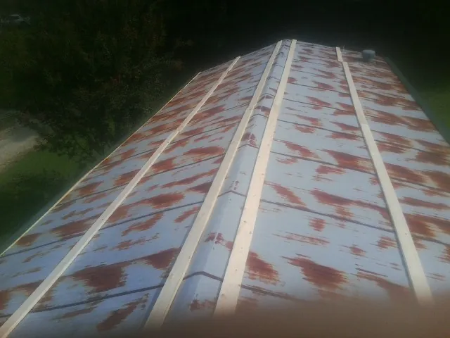 Rusted metal roof panels with new wood purlins before replacement — Storm Damage Roof Repair in Bicknell by Roofing Brothers