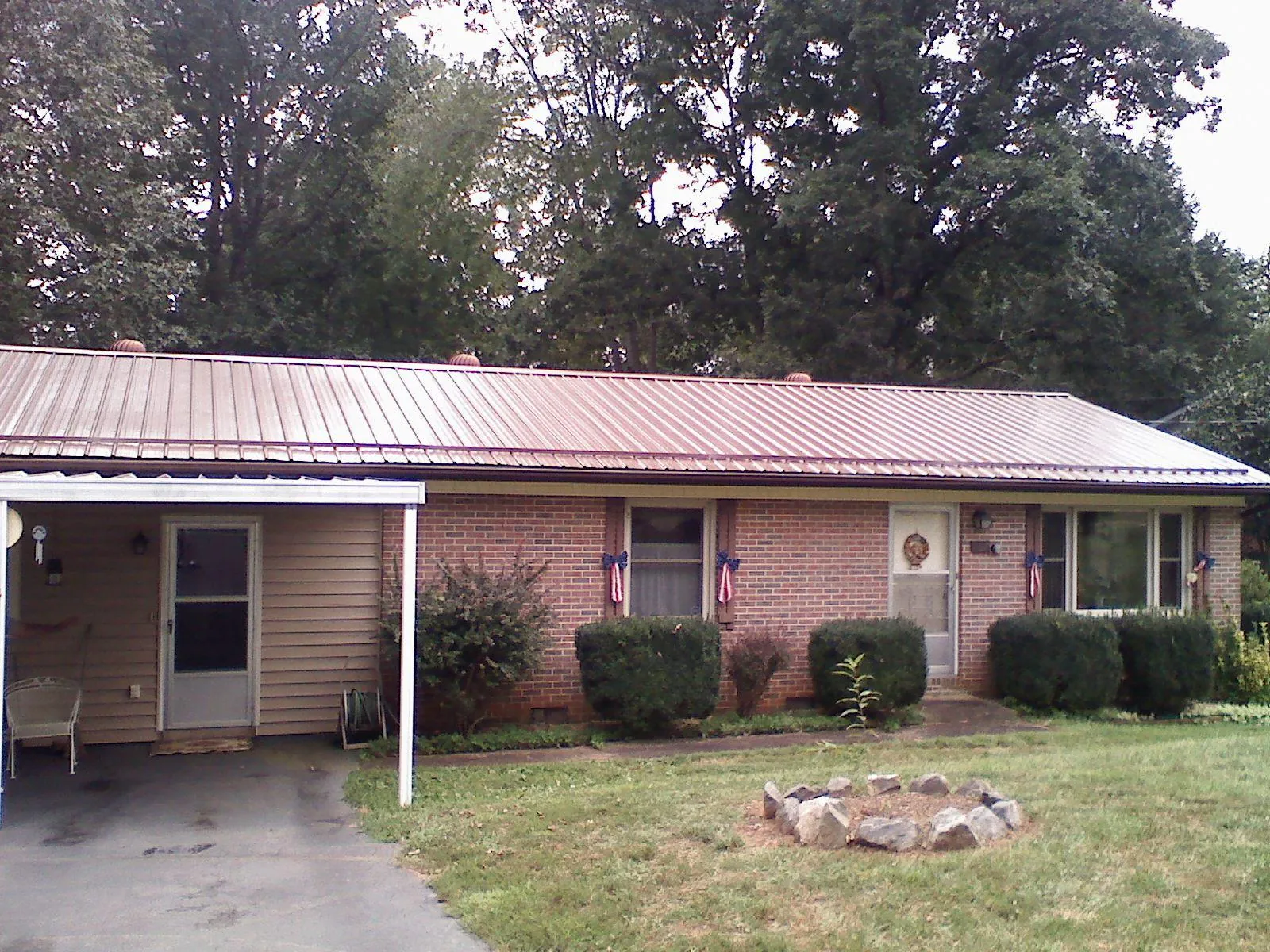 Bronze metal roof and carport on a brick ranch home — Roof Repair work by our crew in Bicknell